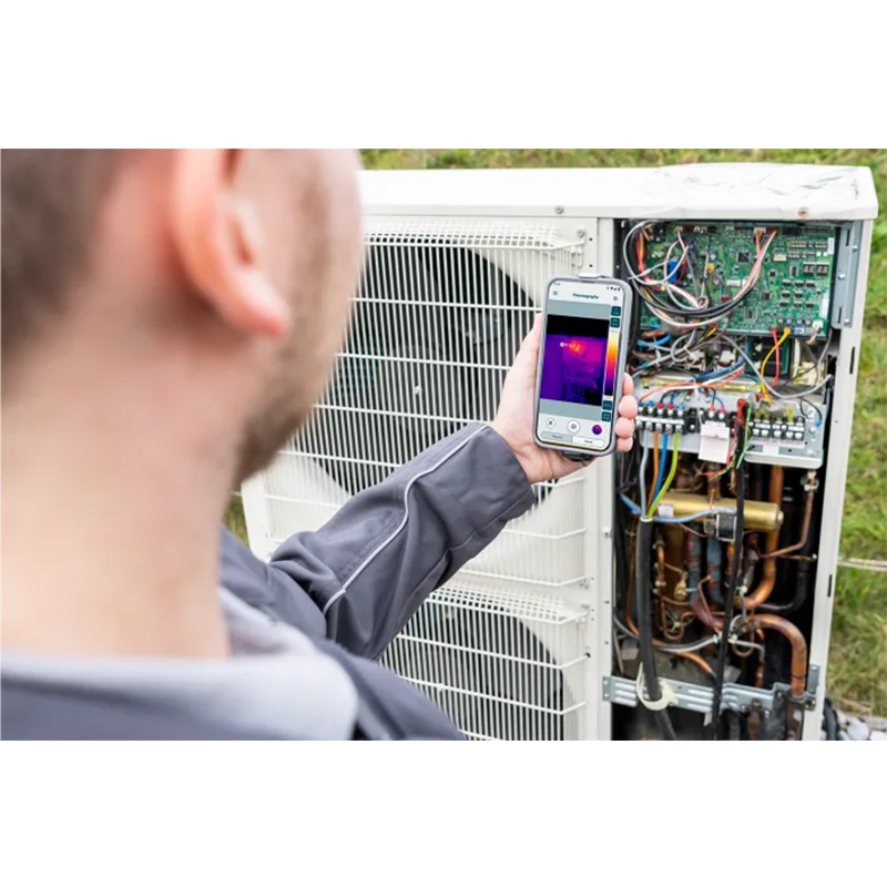 Person using a thermal imaging phone to inspect an air conditioning unit.