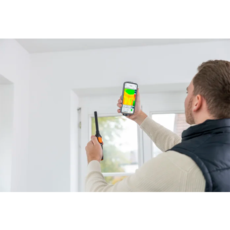 Person using a smartphone app to check energy efficiency of a window